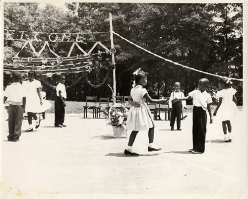 “Children performing a dance routine at an outdoor venue, ca. 1950. This dance was sponsored by Arlington's Negro Recreation Division, part of the Parks and Recreation Department. Source: Center for Local History, Arlington Public Library.