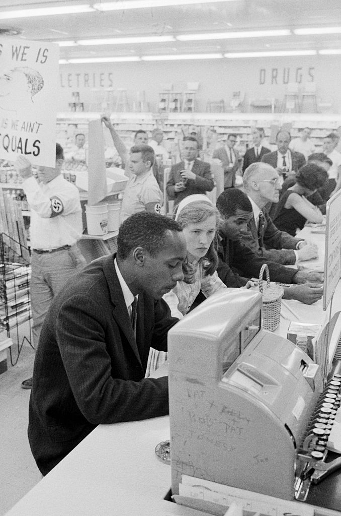 Demonstrators staging a sit-in at a drug store lunch counter in Arlington, VA, are picketed by American Nazi Party (George Lincoln Rockwell's group) members. The sit-in people were trying to break down racial barriers at the drug store lunch counter. Photo by © Wally McNamee/CORBIS/Corbis via Getty Images