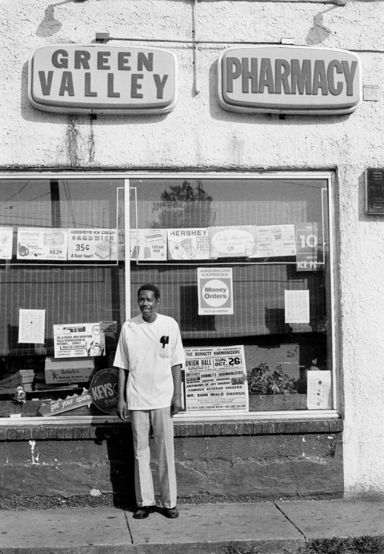Leonard “Doc” Muse in front of Green Valley Pharmacy, 1980. Howard University School of Pharmacy graduate and owner of Green Valley Pharmacy, a fixture of the Nauck community and likely the first Black-owned pharmacy in Arlington. Muse opened the pharmacy in 1952, during a time when most pharmacies did not welcome the Black community. Photo by Lloyd Wolf.